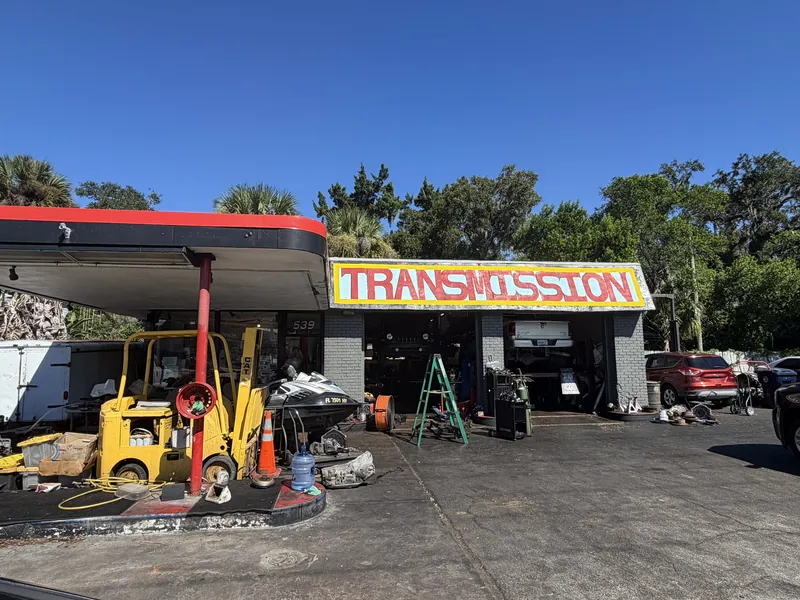 The front of Gary's Transmissions in New Smyrna Beach, Florida, with the hand-painted TRANSMISSION sign over the open service bays
