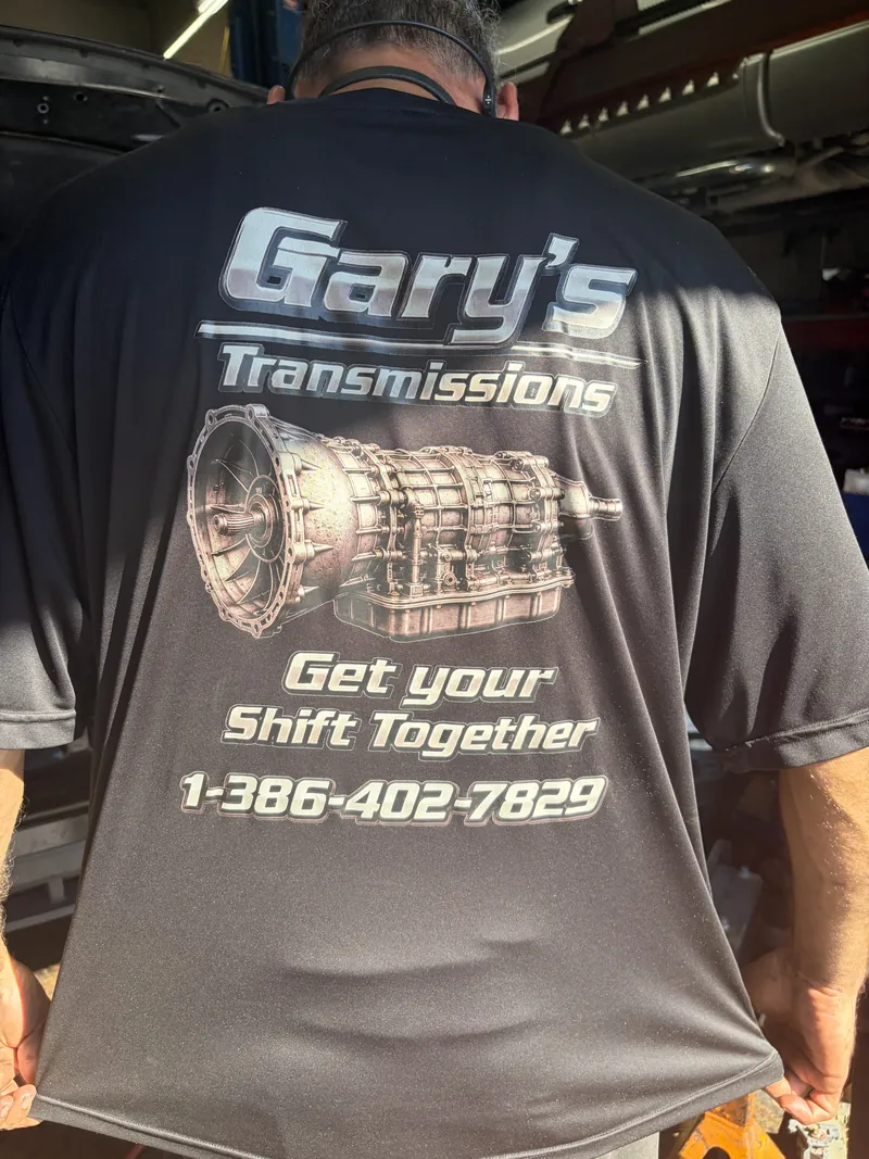 The back of a Gary's Transmissions shop shirt reading Get Your Shift Together, 1-386-402-7829