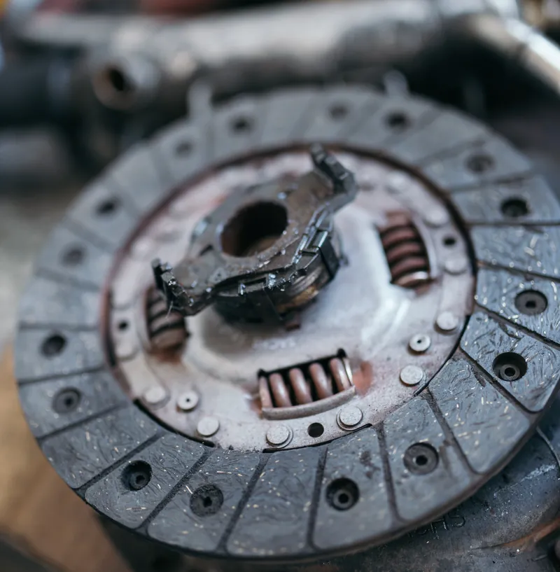 Close-up of a worn clutch disc on a workbench